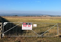 A shut gate with a keep out sign